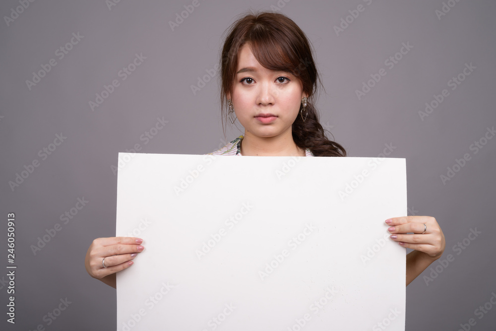 Asian woman holding empty white board with copyspace Asian woman holding empty white board with copyspace