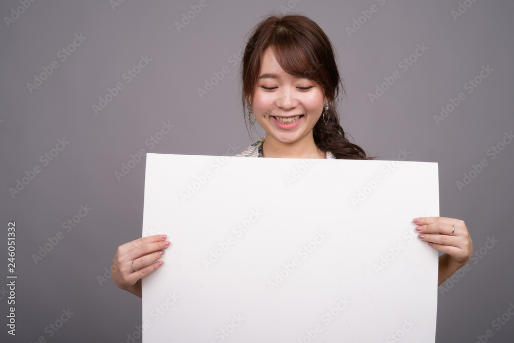 Asian woman holding empty white board with copyspace Asian woman holding empty white board with copyspace