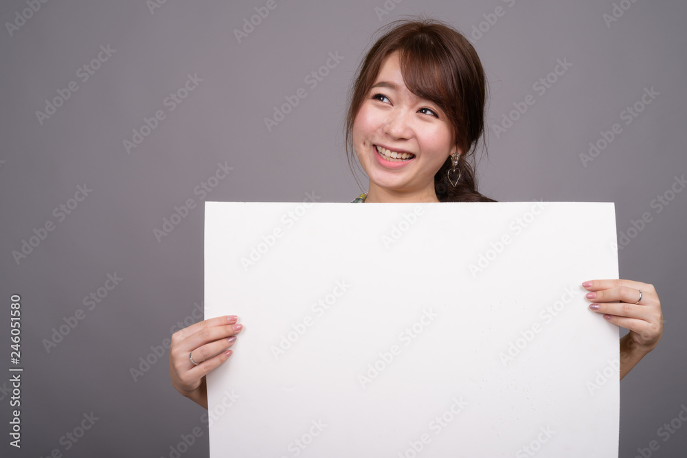 Asian woman holding empty white board with copyspace Asian woman holding empty white board with copyspace