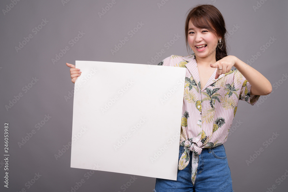 Asian woman holding empty white board with copyspace Asian woman holding empty white board with copyspace