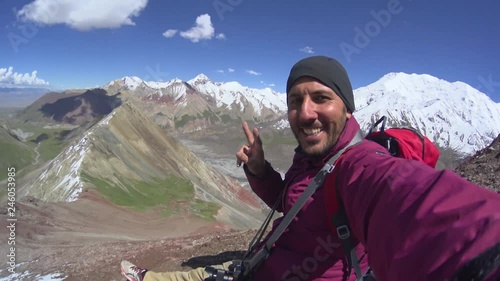 Man climber making a selfie on the top of the mountain near the Lenin peak mountain in Kyrgyzstan, Central Asia