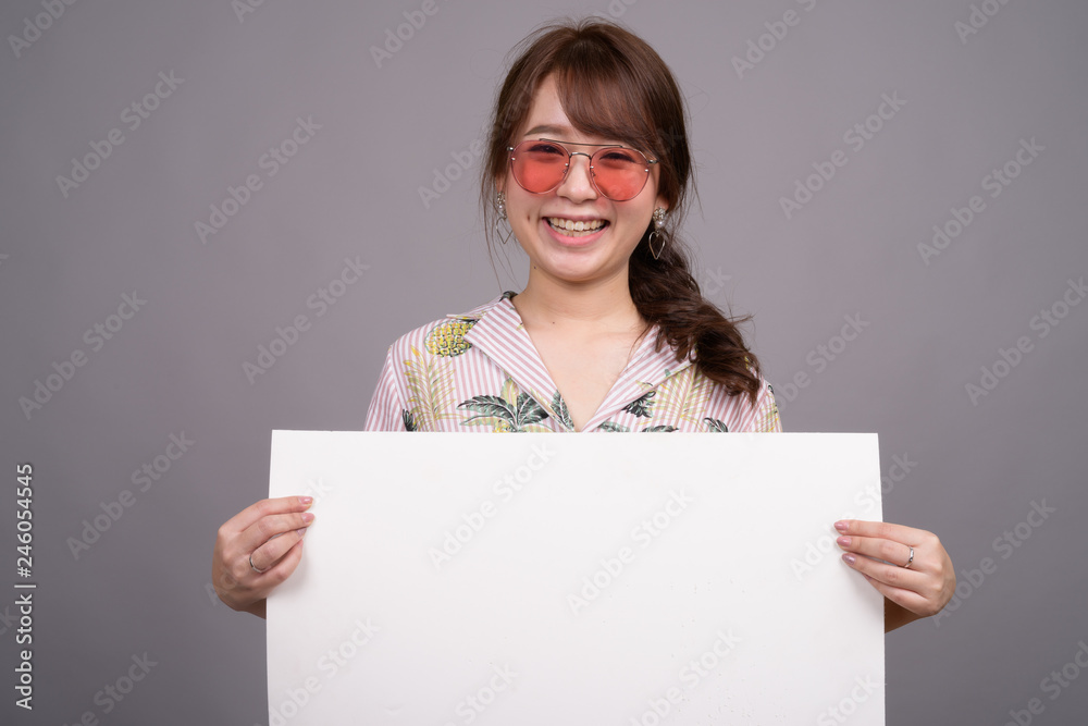 Asian woman holding empty white board with copyspace Asian woman holding empty white board with copyspace