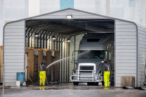 Big rig semi truck washes in covered car wash station with manual washing photo