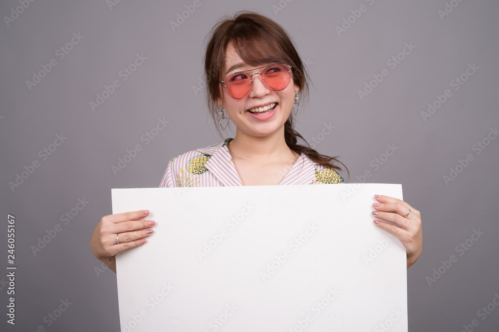 Asian woman holding empty white board with copyspace Asian woman holding empty white board with copyspace