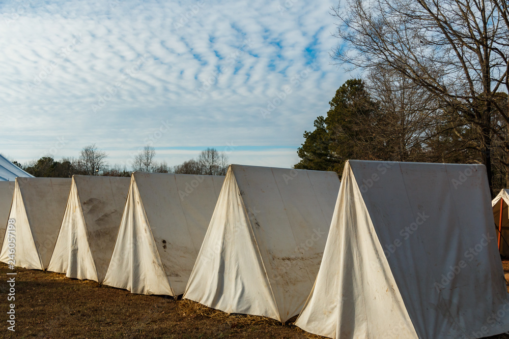 small row of white tents with blue sky