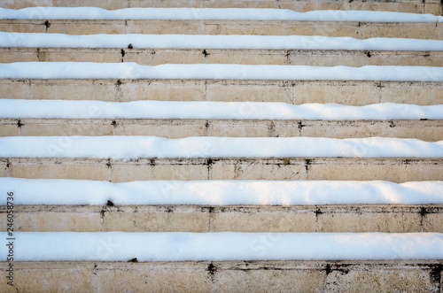 Old rusty marble stairs covered with snow 