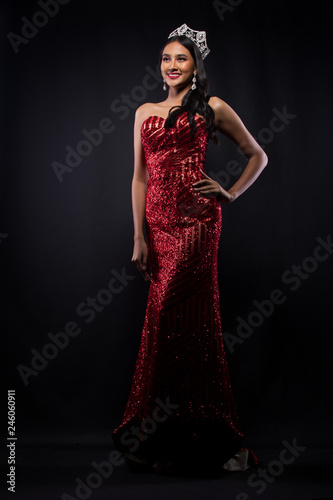 Full Length of Miss Pageant Contest in Asian woman Red Evening Ball Gown dress with Diamond Crown Sash, fashion make up face eyes love hair style, studio lighting dark background isolated copy space