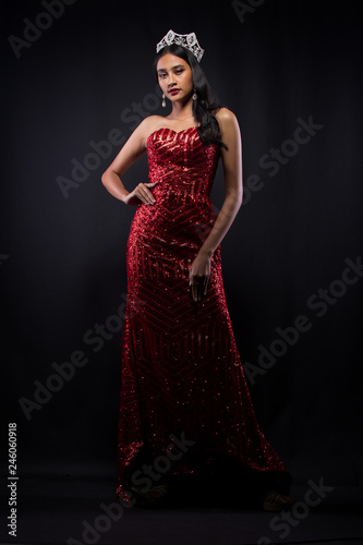 Full Length of Miss Pageant Contest in Asian woman Red Evening Ball Gown dress with Diamond Crown Sash, fashion make up face eyes love hair style, studio lighting dark background isolated copy space