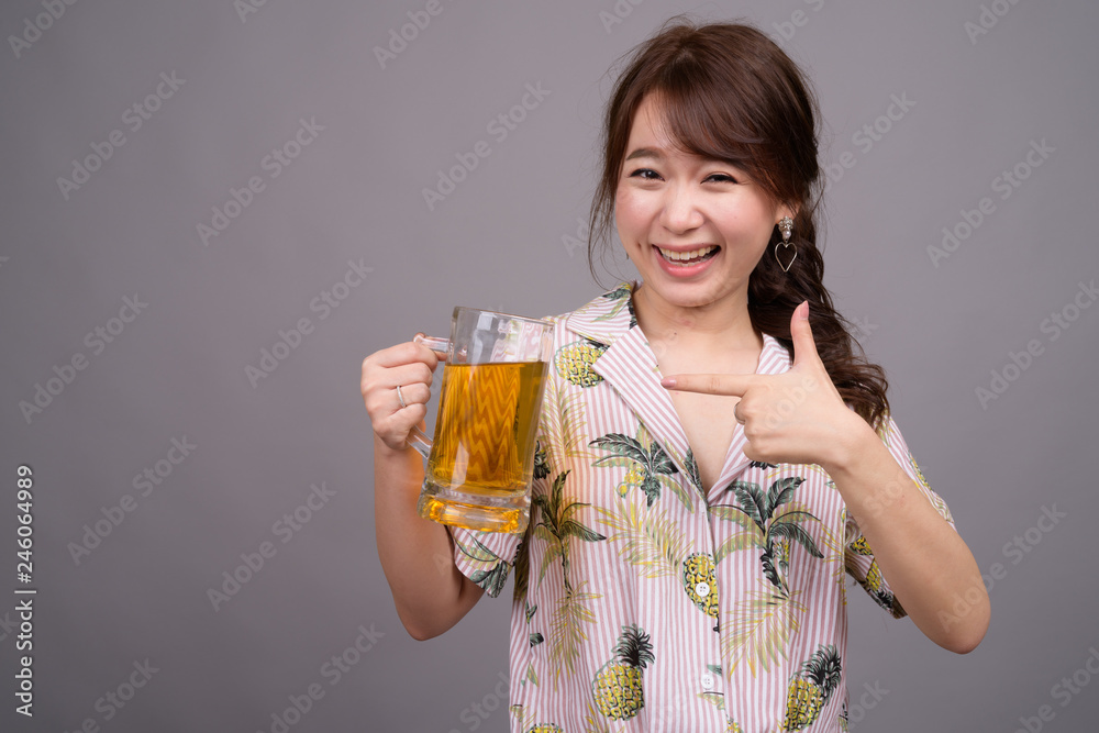 Young beautiful Asian tourist woman holding glass of beer Young beautiful Asian tourist woman holding glass of beer