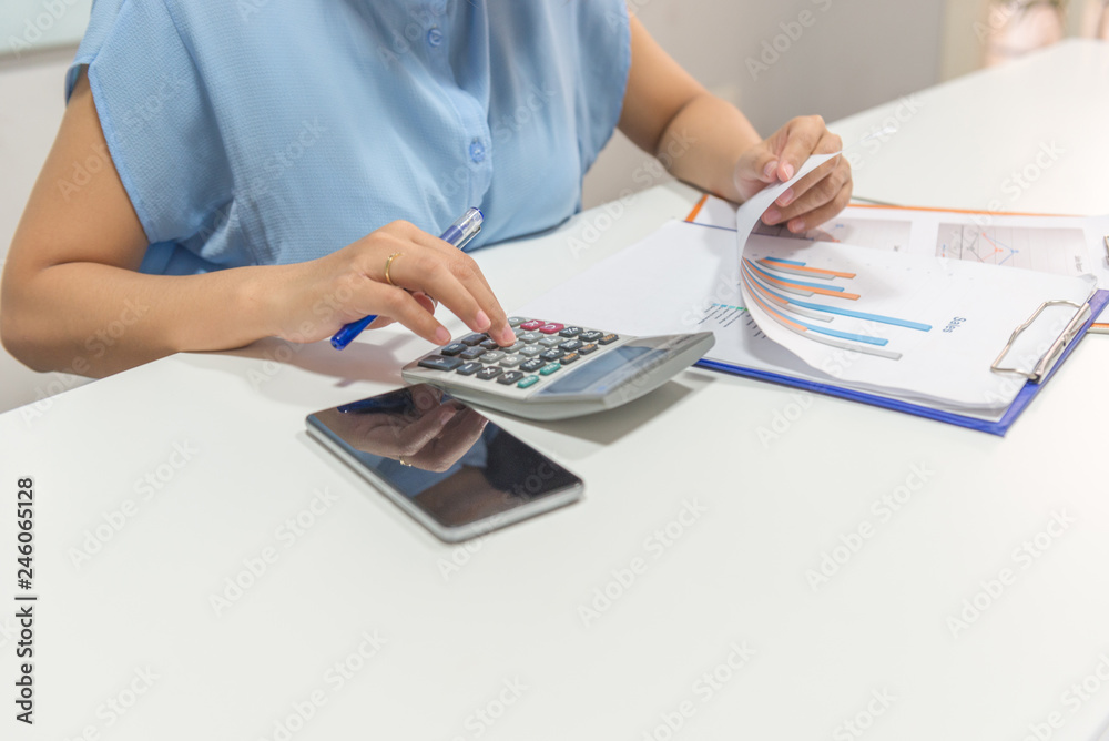 Close-up of woman hand calculate sales on the calculator Close-up of woman hand calculate sales on the calculator