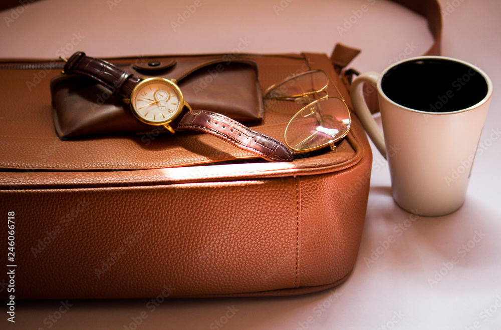 Conjunto de Accesorios para Hombre en tonos café y dorado de estilo formal  / estilo vintage y elegante para hombre , lentes, maletín, reloj, taza,  estuche de lentes. Stock Photo