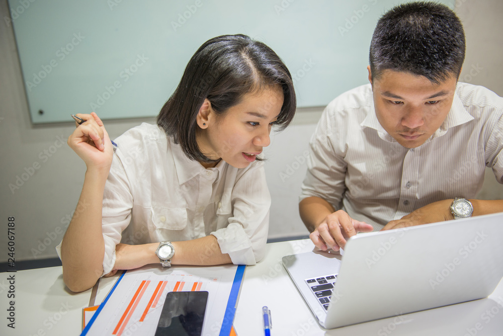 Two Asian office employees working in a team