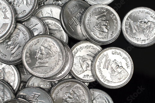 A close up image of a pile of silver Pakistani one rupee silver coins photo