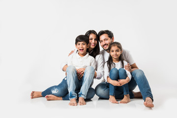Young Indian/asian family sitting isolated over white background. selective focus
