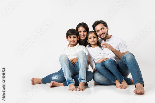 Playful Indian/asian family sitting isolated over white background. selective focus photo