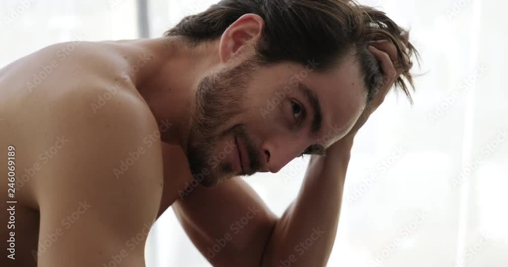 Portrait of beautiful young white man looking at camera. Handsome sensual hispanic male athlete smiling while touching thick hair. Slow motion and happy latino people. Slow motion