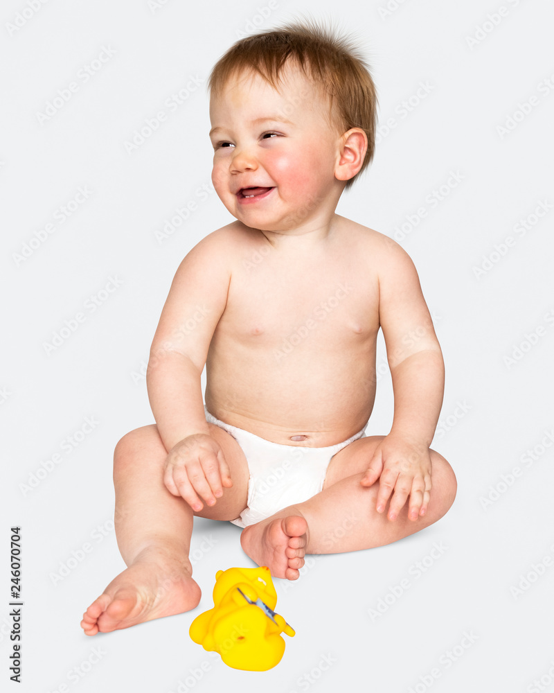 Baby in a diaper sitting on the floor Baby in a diaper sitting on the floor