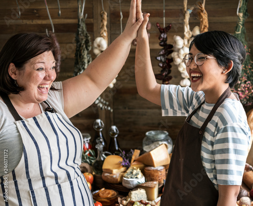 Women giving a high five at a deli shop