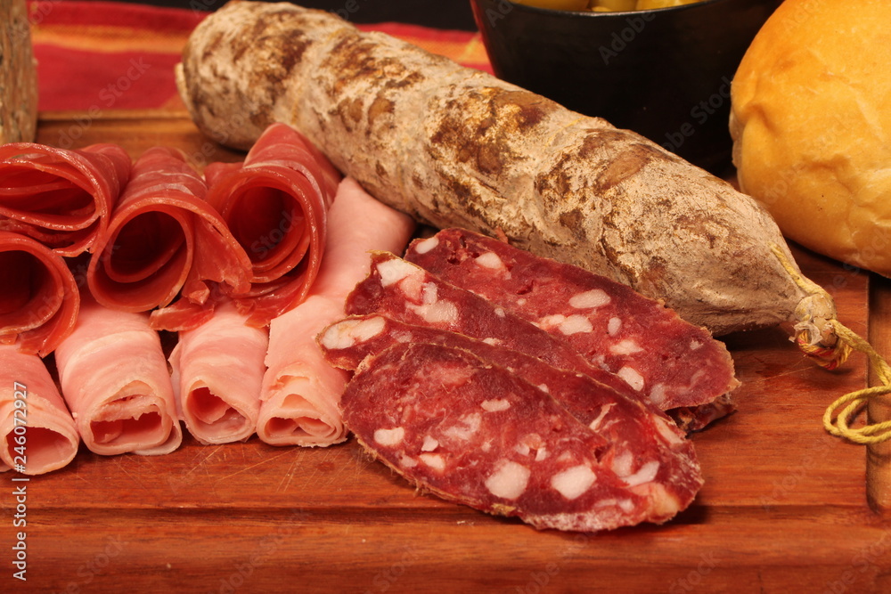 Food tray with delicious salami, pieces of sliced ham and chesses Food tray with delicious salami, pieces of sliced ham and chesses