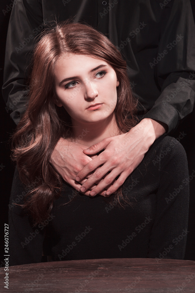 Young girl and male hands on a black background