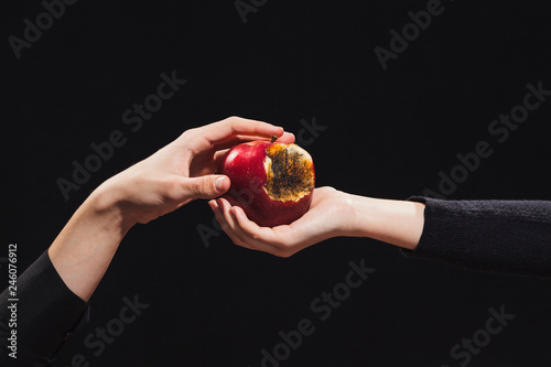 Foto Rotten apple of knowledge, a young girl gives it to a man