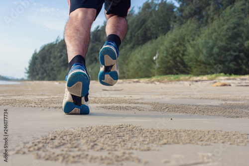 Man run on the beach, closeup on shoes