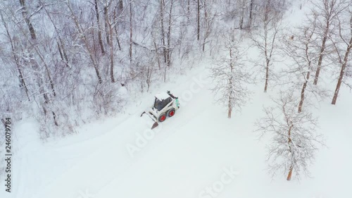 Clearing snow on a rural property with a wheeled bobcat photo