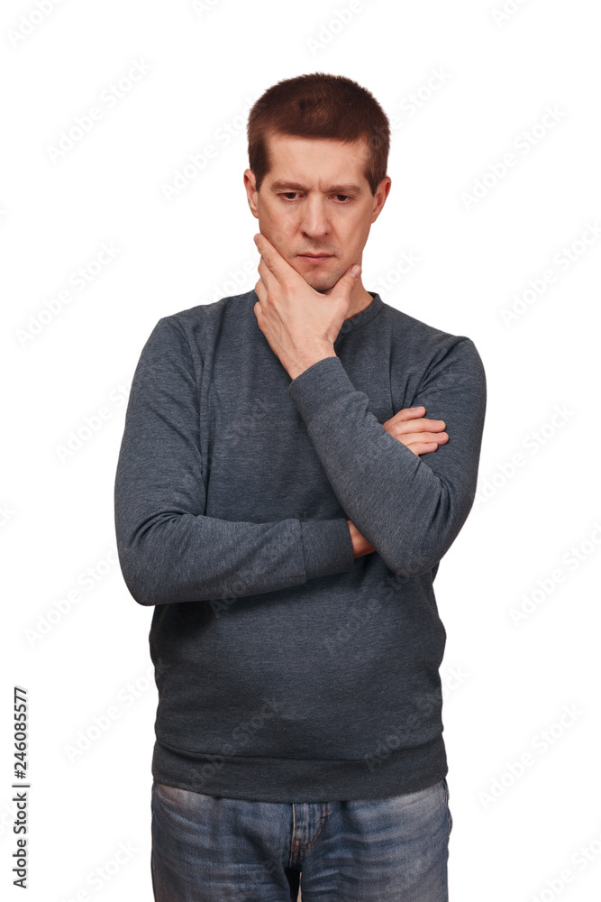 The thoughtful man is dressed in long sleeved t-shirt, jeans and holds a hand about the head The thoughtful man is dressed in long sleeved t-shirt, jeans and holds a hand about the head
