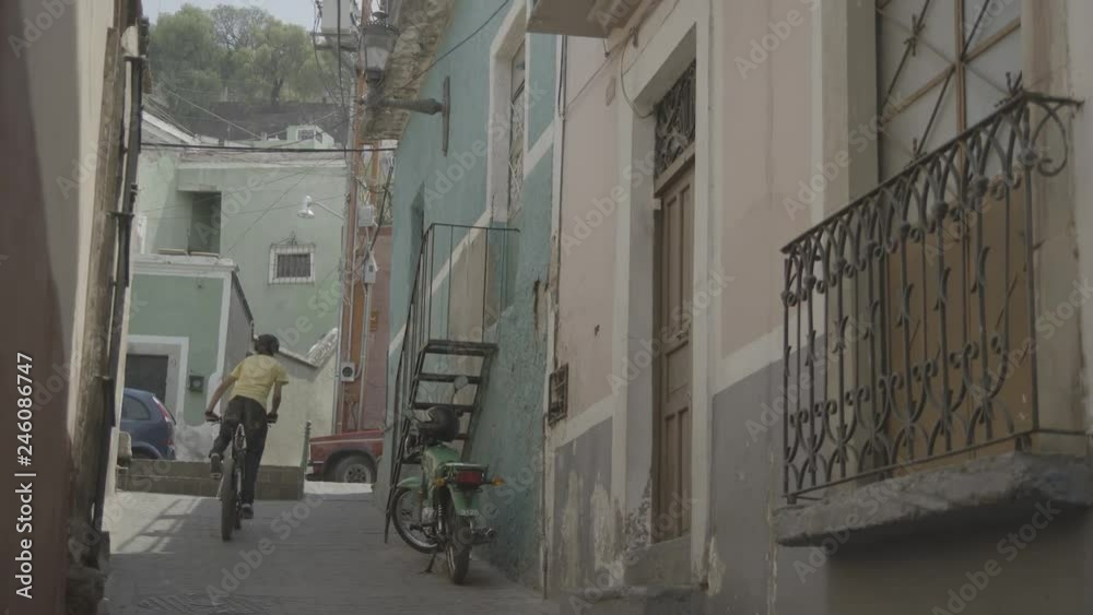 Boy riding His Bike Up An Alley Boy riding His Bike Up An Alley