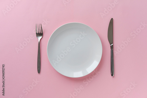 Clean white ceramic plate with knife and fork