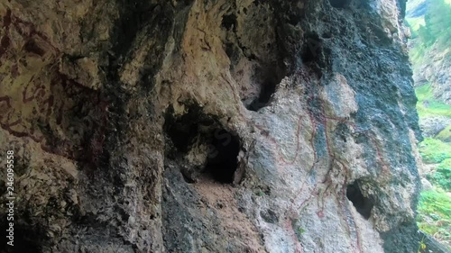 Footage of a cave in the Dolomites - Mazzin valley. Gratifies painted on the cave. photo