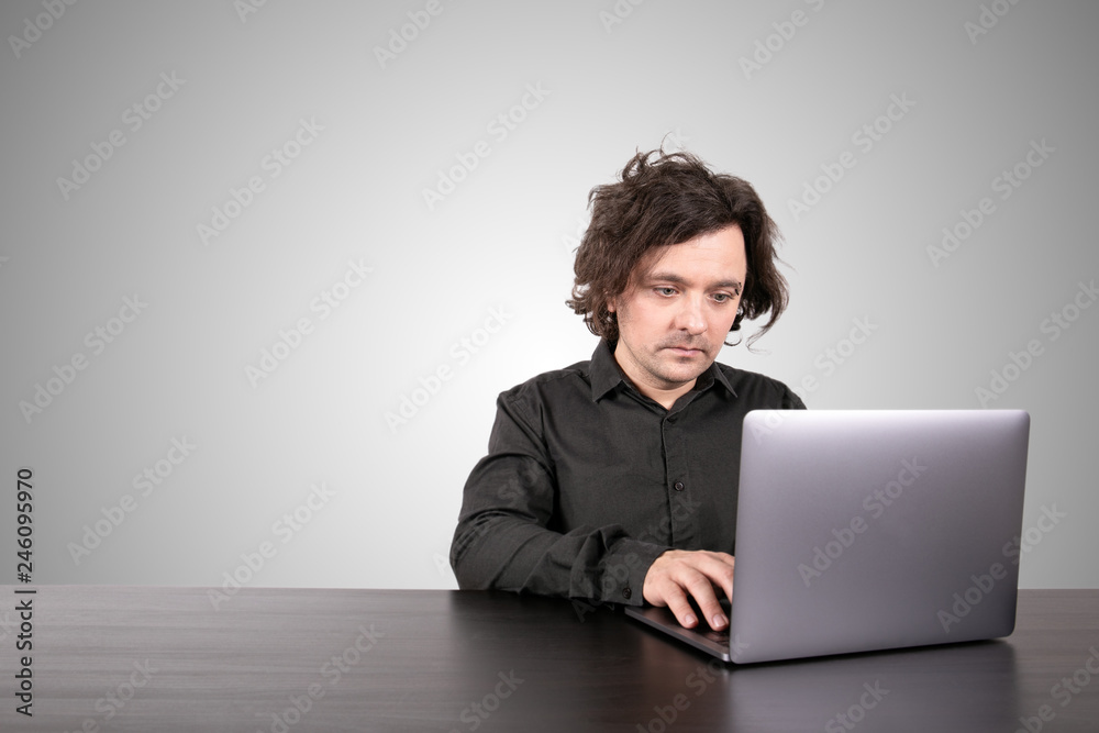 Businessman working on laptop at office. Gray background with copy space Businessman working on laptop at office. Gray background with copy space