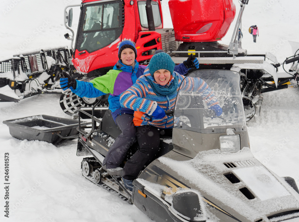 Fototapeta premium Lead sit on a snowmobile on a snow slope.