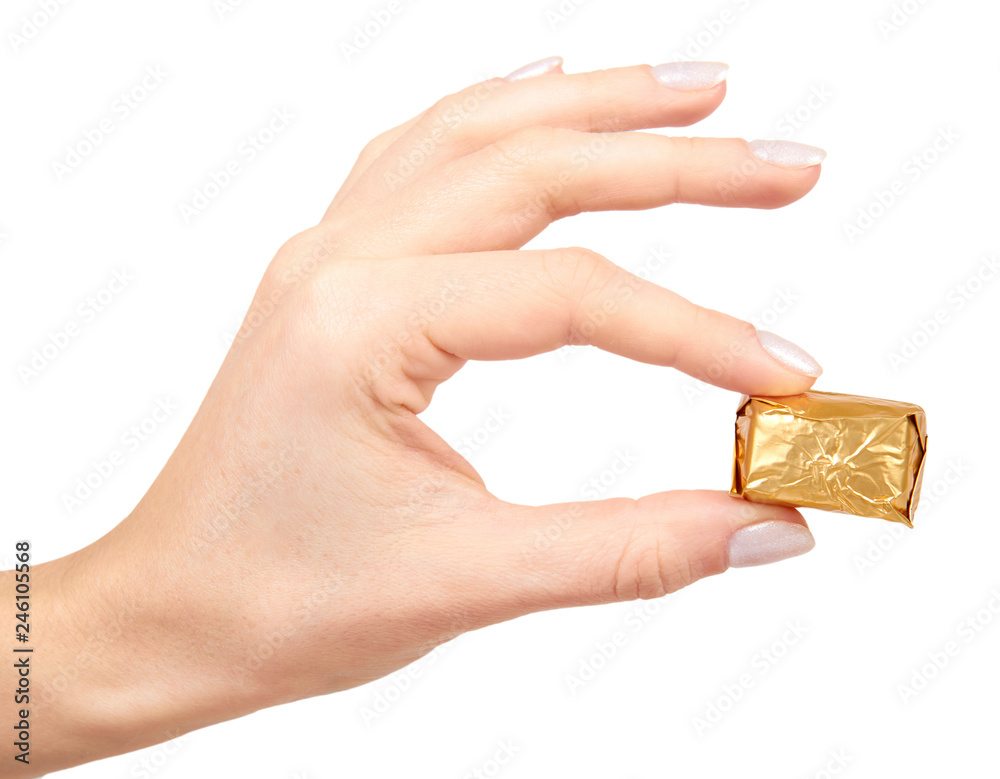 Fototapeta premium Hand with chocolate candy, sweet dessert closeup