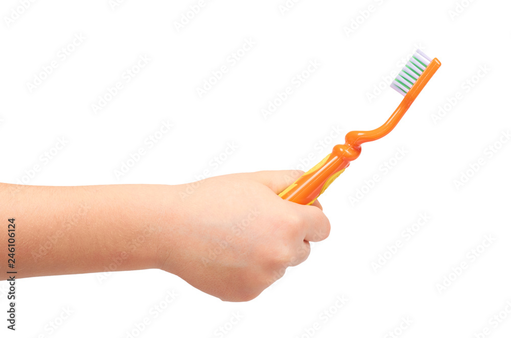 Kids hand with orange toothbrush, dental care concept Kids hand with orange toothbrush, dental care concept