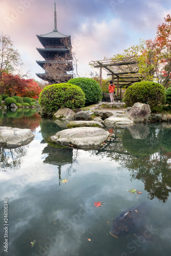 Ancient wood pagoda with fish in autumn garden at Toji temple