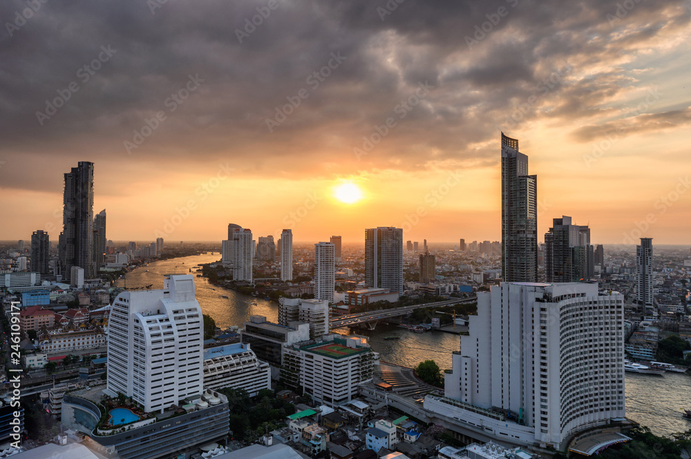 Fototapeta premium Cityscape of skyscraper with Chao Phraya river at sunset in Bangkok
