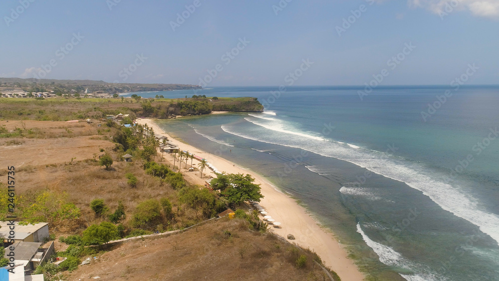 Aerial view rocky seashore with sandy beach. seascape ocean surf and tropical beach large waves turquoise water crushing on beach Bali,Indonesia. Travel concept.