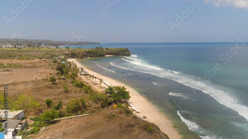 Aerial view rocky seashore with sandy beach. seascape ocean surf and tropical beach large waves turquoise water crushing on beach Bali,Indonesia. Travel concept.