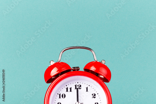Half part of red alarm clock on blue background with copy space. photo