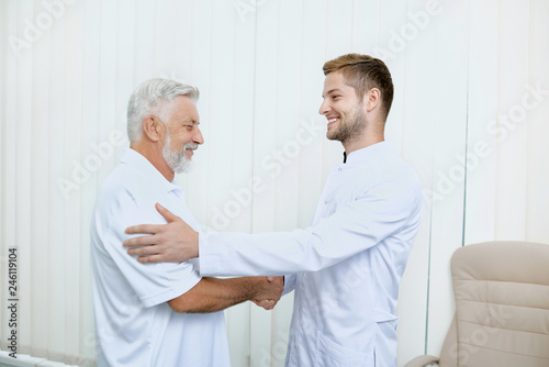 Portrait of two smiling specialist shaking hands.
