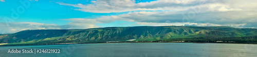Golan Heights and Tiberian Lake panorama where green hills, blue sky with clouds