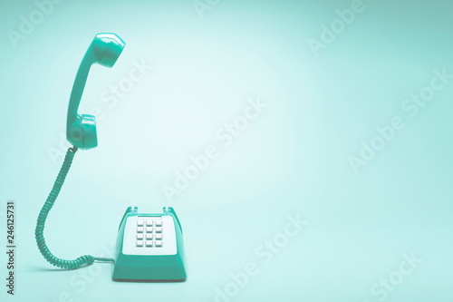 Retro green telephone on teal green background