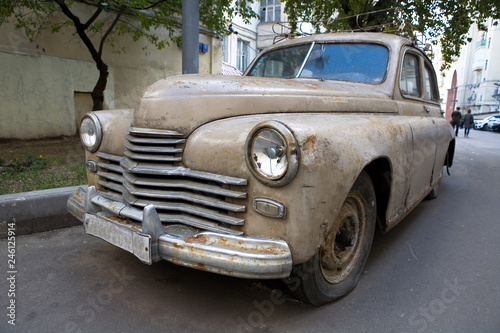 Old rusty car with a broken headlight.
