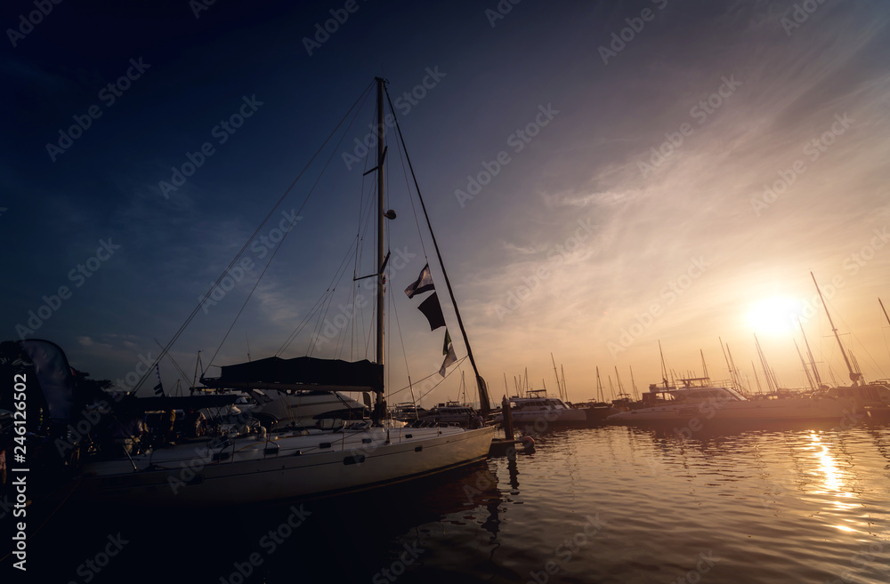 Beautiful view of marina and harbor with yachts and motorboats. Sunset at the ocean.