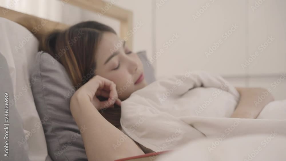 Beautiful young Asian woman reading a book while lying on the bed, Female sleep after relax in bedroom at home. Lifestyle women using relax time at home concept. Beautiful young Asian woman reading a book while lying on the bed, Female sleep after relax in bedroom at home. Lifestyle women using relax time at home concept.