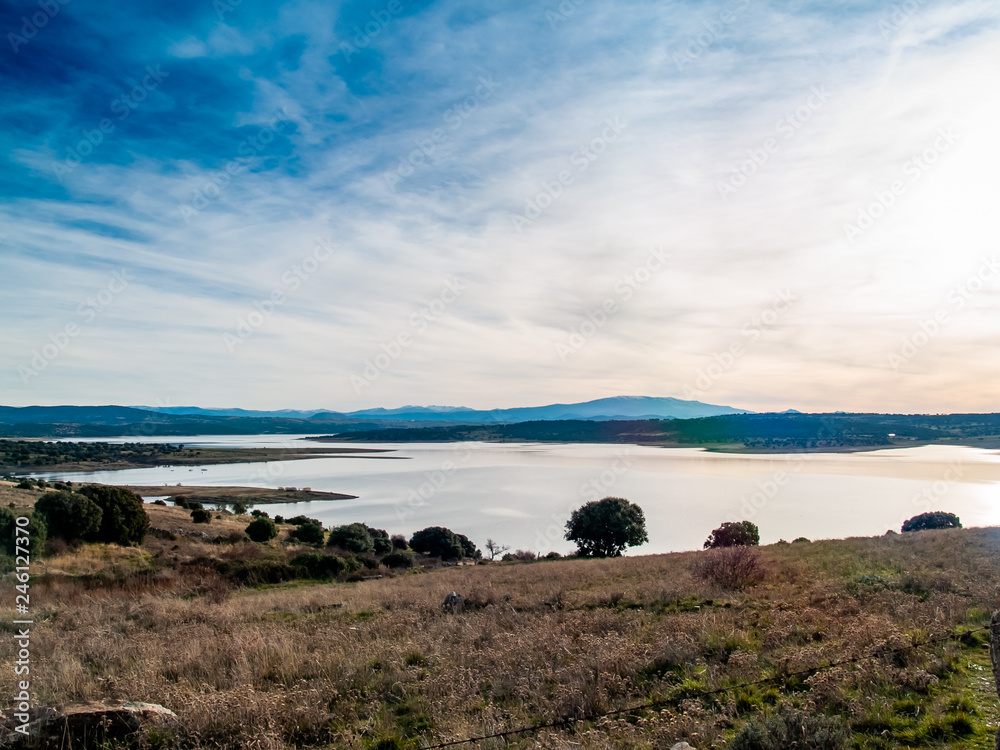 Landscape of a reservoir and mountains in a day with fog and clouds and birds swimming and flying in in La Maya Reservoir (Salamanca) Landscape of a reservoir and mountains in a day with fog and clouds and birds swimming and flying in in La Maya Reservoir (Salamanca)