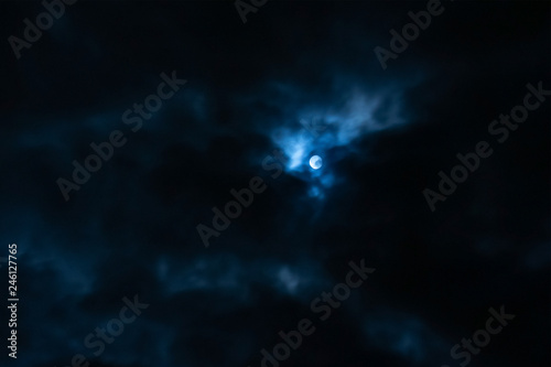 Fototapeta Naklejka Na Ścianę i Meble -  The white moon in the dark blue clouds of night.