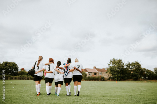 Female football players huddling and walking together