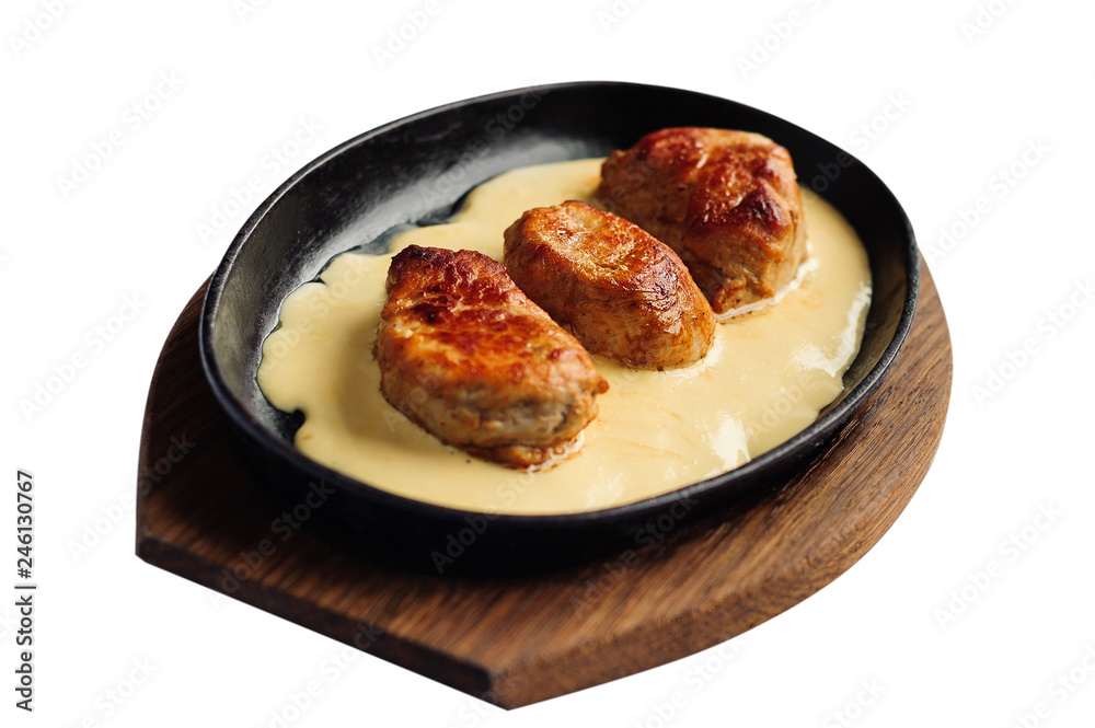 Juicy pork medallions in sauce on the iron pan Juicy pork medallions in sauce on the iron pan